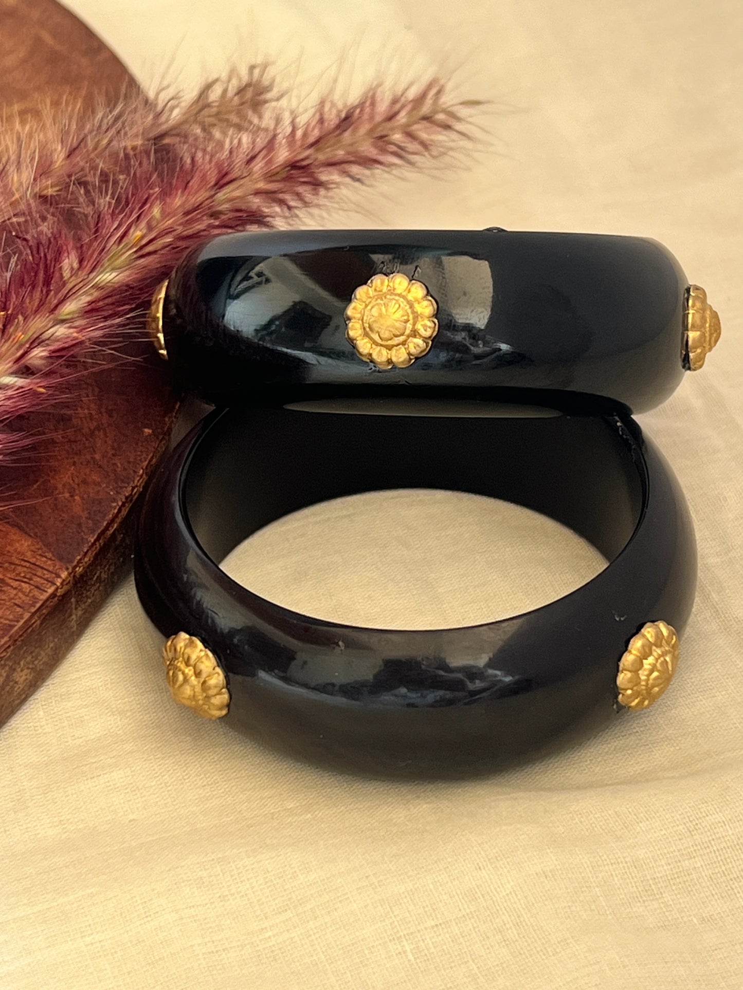Black resin bangles with gold motifs