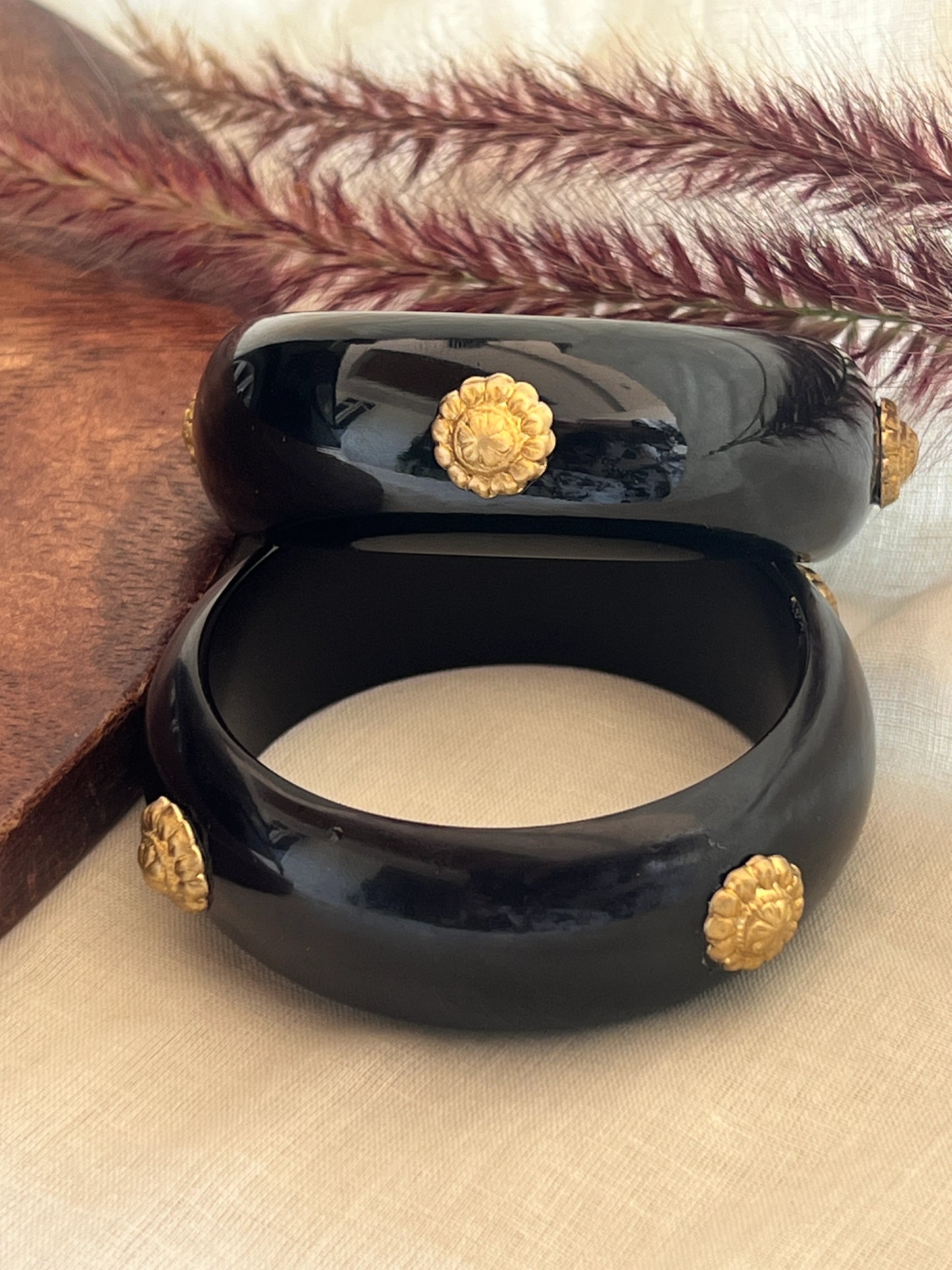 Black resin bangles with gold motifs