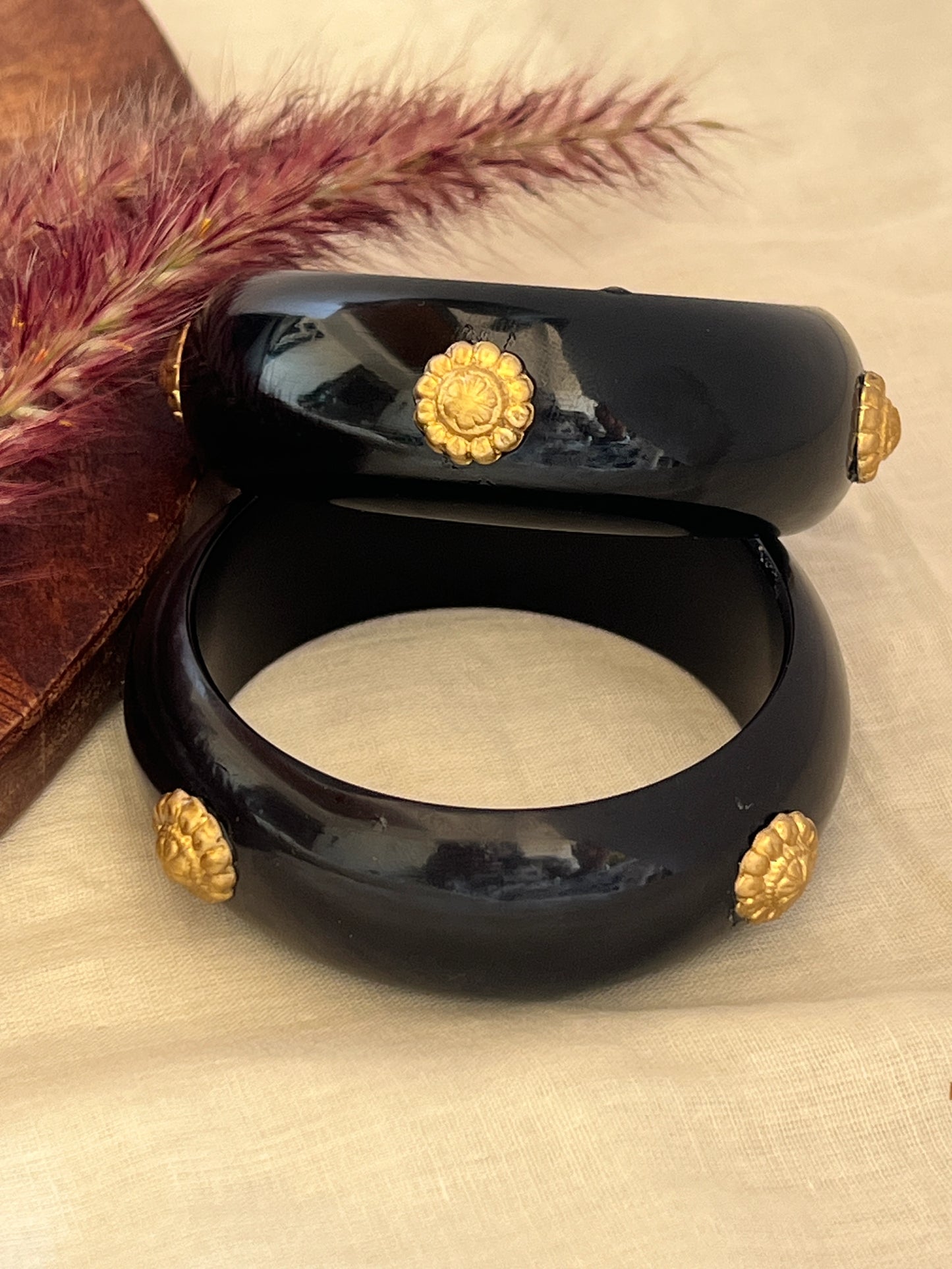 Black resin bangles with gold motifs